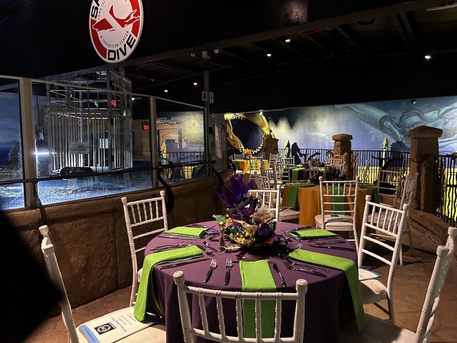 Table setting in purple and green at aquarium mezzanine by shark dive sign