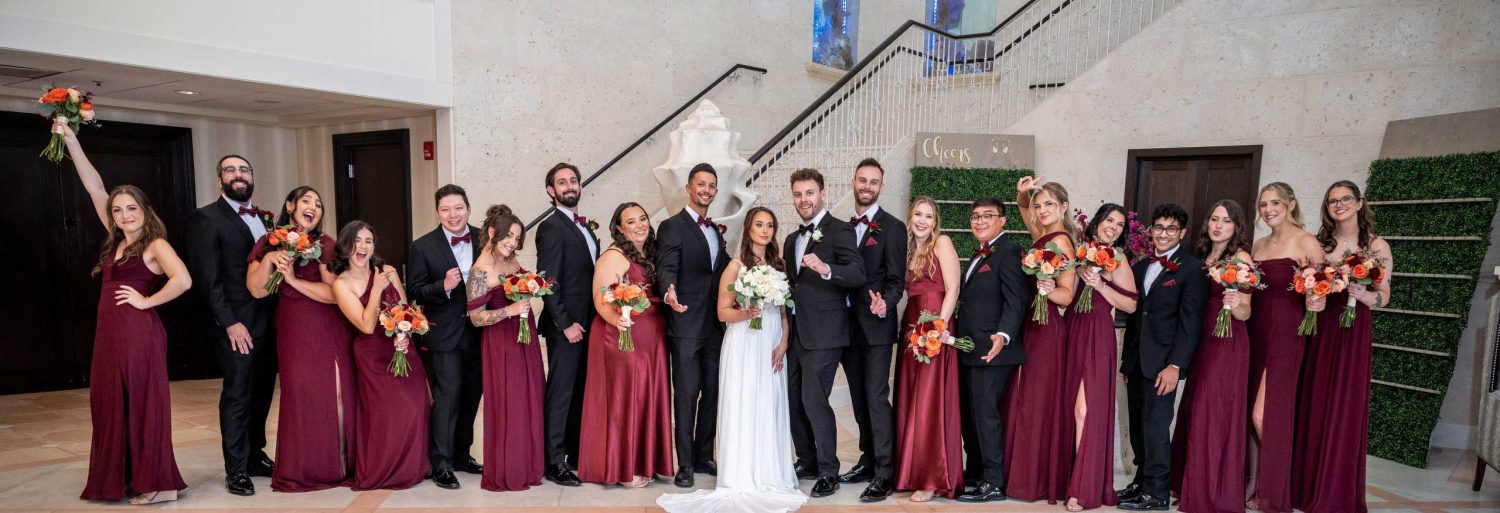 Bride and groom surrounded by their wedding party at a reception venue